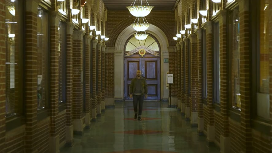 CIA graduate Frank Pinello ’06 walking down hallway in Roth Hall.