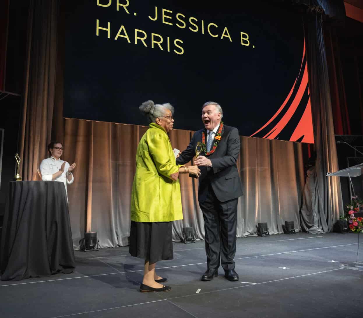 Dr. Jessica B. Harris receives an award on stage from CIA President Tim Ryan.