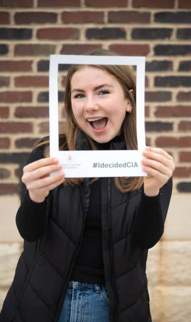 CIA student at Accepted Student Day holding her hands in front of her face to make a frame.
