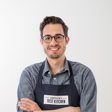Cook’s Illustrated editor in chief and CIA alumnus Dan Souza smiling with arms folded.