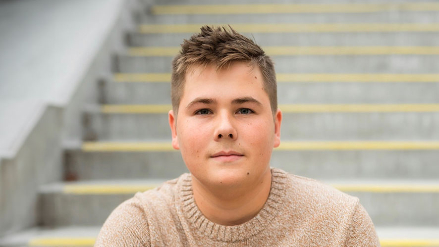 Image of CIA student Hudson Parker ‘25 sitting on steps outside.