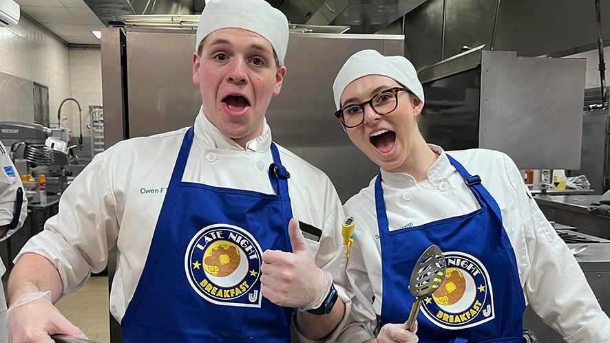 Image of two CIA students working in the kitchen for the Late-Night Breakfast at CIA’s Hyde Park, NY campus.