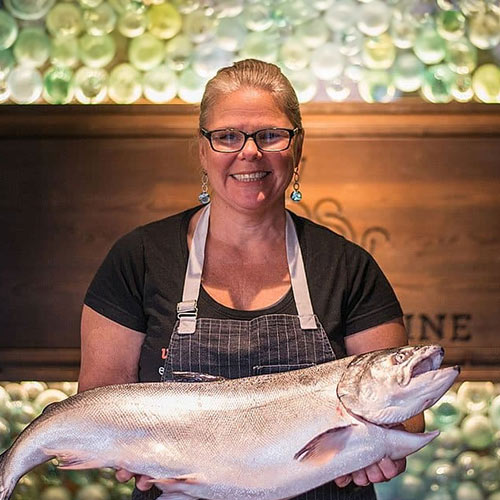 Image of CIA alumnae Jennifer Jasinski ’89 holding a uncooked fish.