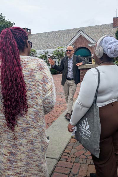 Image of CIA Professor Dr. Taylor Reid talking to students in front of the Post Road Brew House.