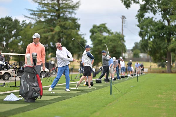 Image of men hitting golf balls at a local driving range.