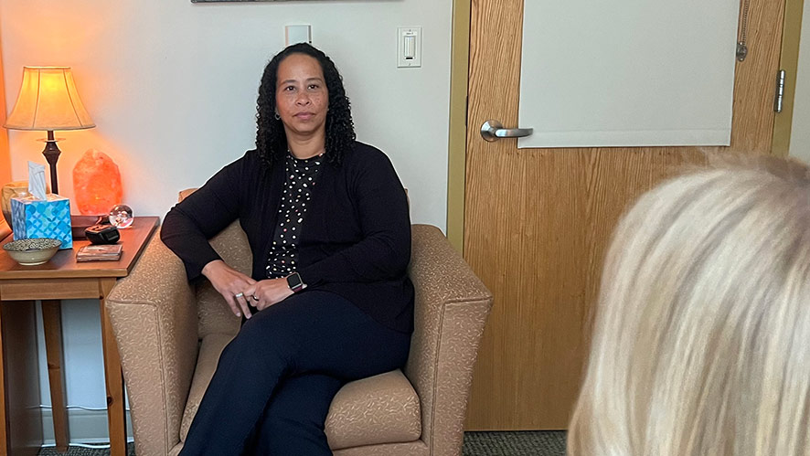 Image of a CIA CAPS employee sitting in an office talking to another person.