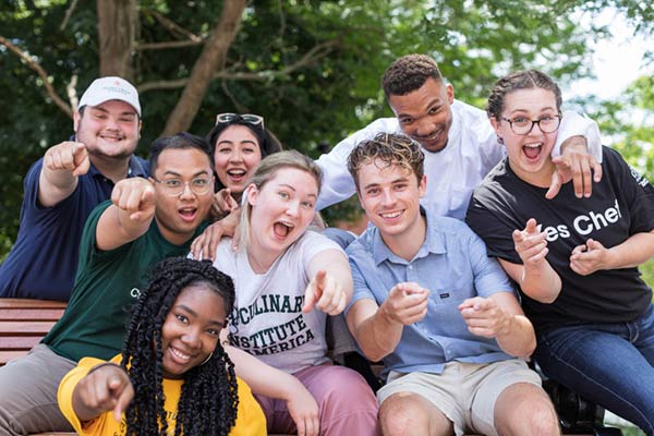 Image of smiling CIA students sitting on a bench.
