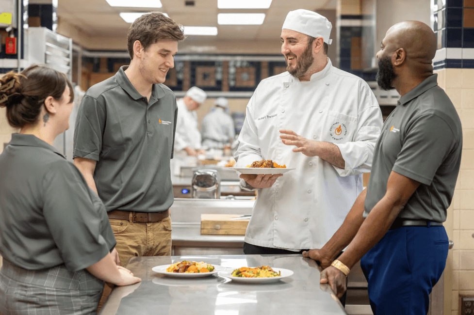 The Care Team at CIA's School of Graduate Studies Culinary Therapeutics masters degree program review different plates of food.