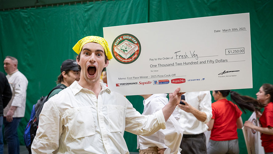 Image of Matty Friedman celebrating his victory in CIA’s Pizza Cook-Off as a member of the Hudson Valley Forest Floor team.