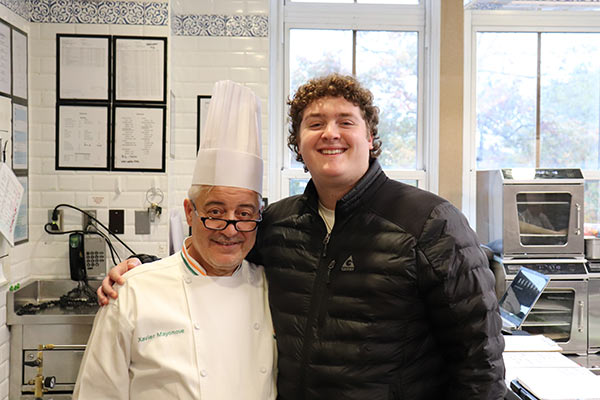 Image of Chef-Instructor Xavier Mayonove and Sidney Rubenstein ’22 standing in a CIA kitchen in Hyde Park, NY.